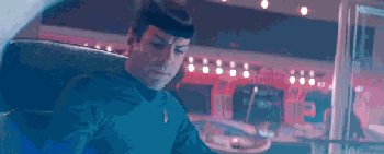 Gif showing Spock sat in the captain's chair during a turbulent flight, he presses a button of the chair and and updated seat belt harness to Picard's unfolds itself across his lap and shoulders